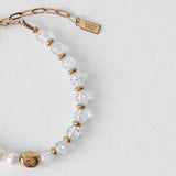 Détail du fermoir en acier inoxydable doré et du pendentif Komète Atelier sur le bracelet Kaleb en perles d’eau douce et quartz craquelé naturel.