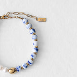 Détail du bracelet Kaleb Komète Atelier en perles de porcelaine bleue et perles d’eau douce naturelles, acier inoxydable doré à l’or 18 carats.