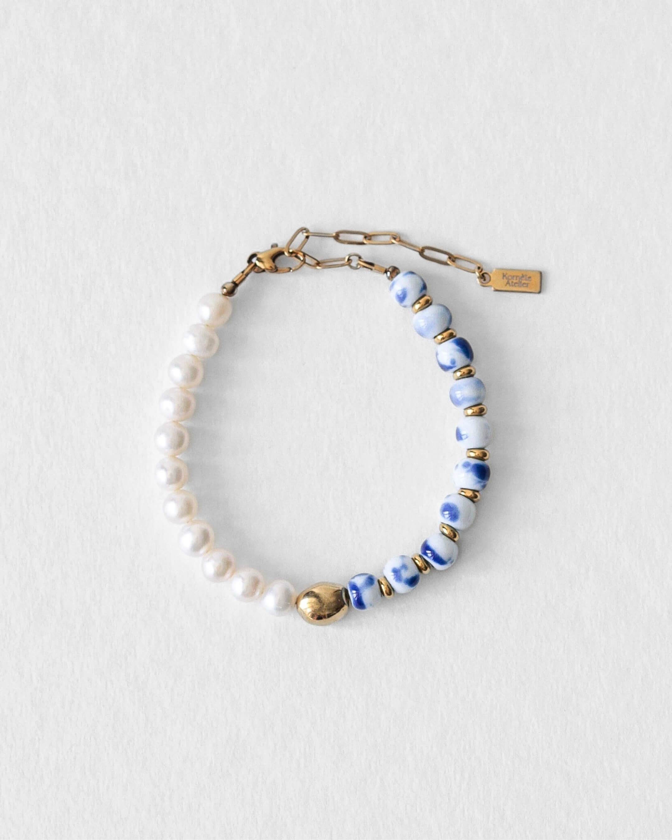 Bracelet Kaleb en perles d’eau douce et porcelaine bleue, bijou unisexe Komète Atelier fait main en acier inoxydable doré à l’or 18 carats, résistant à l’eau.
