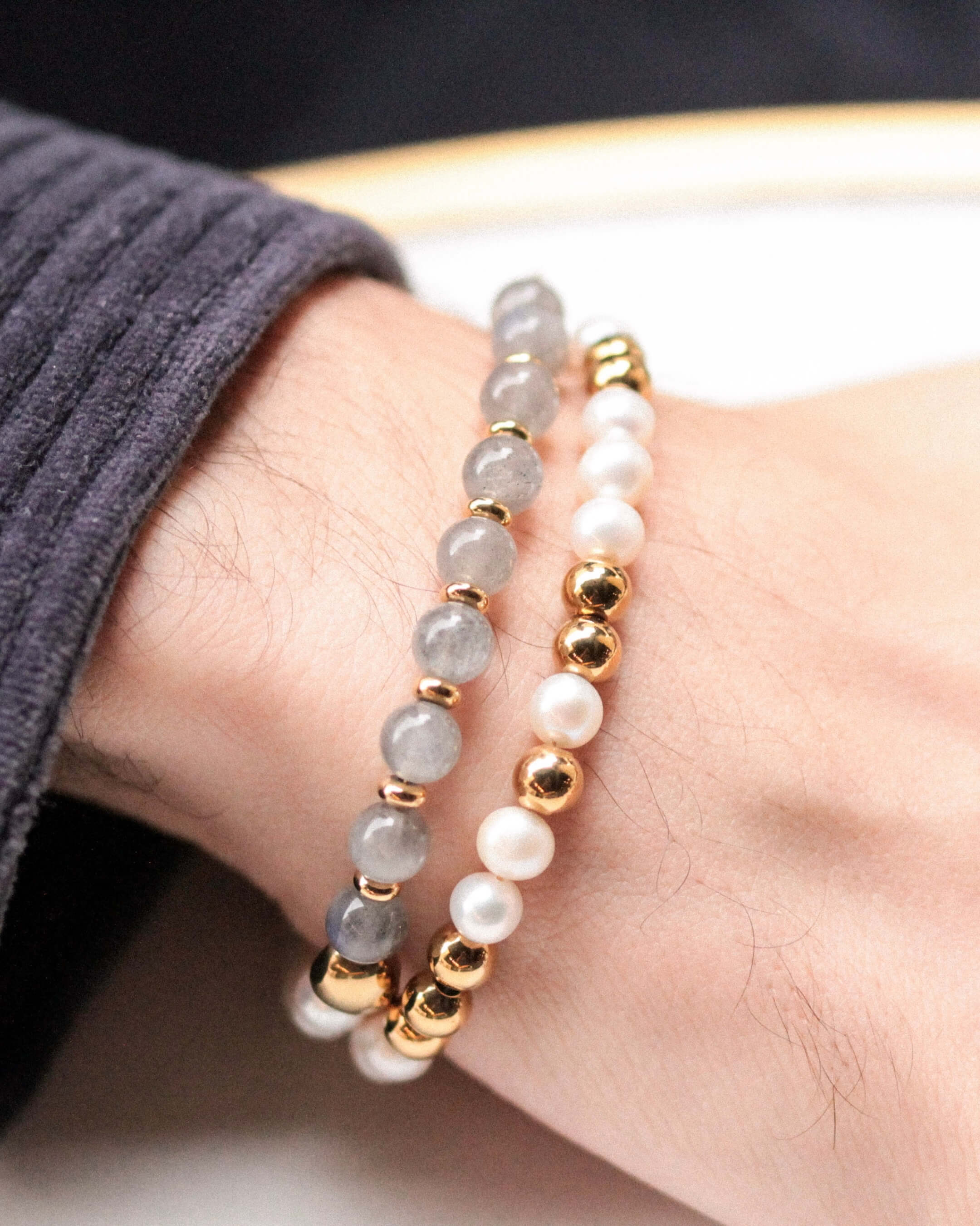 Zoom sur le bracelet Kaleb Komète Atelier, bijou fait main en acier inoxydable doré à l’or 18 carats, orné de perles d’eau douce et de labradorite.