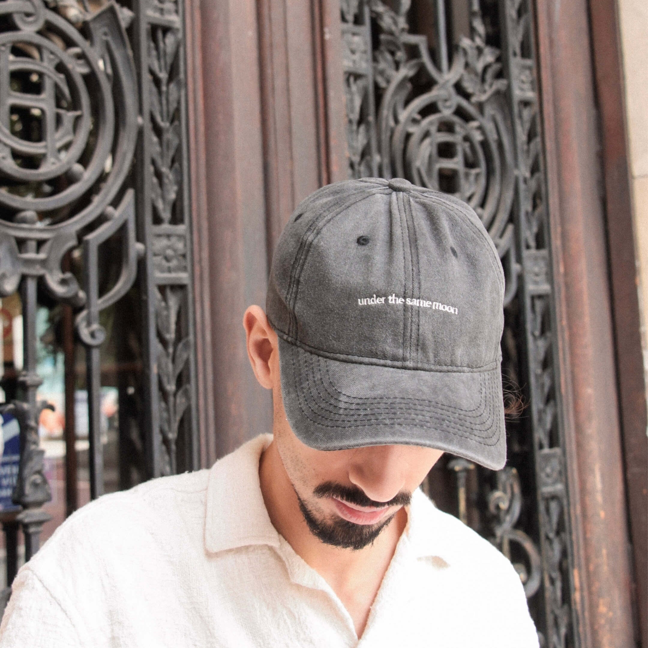 Casquette Komète Atelier gris foncé portée, broderie avant visible, ambiance douce et décontractée