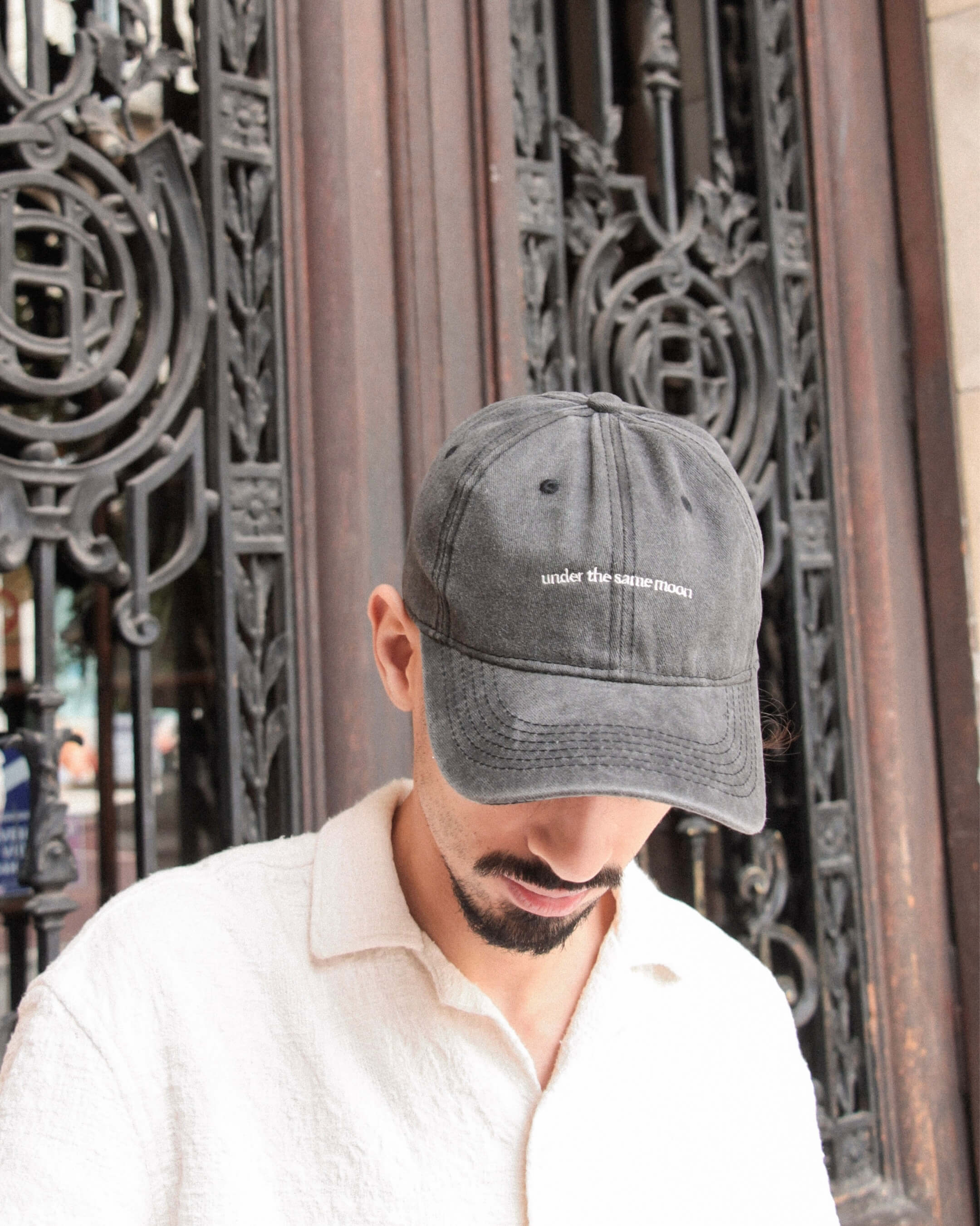 Casquette Komète Atelier gris foncé portée, broderie avant visible, ambiance douce et décontractée