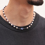Collier Celest porté par un homme, perles de culture blanches et lapis-lazuli bleu, étoile centrale, bijou unisexe tendance.