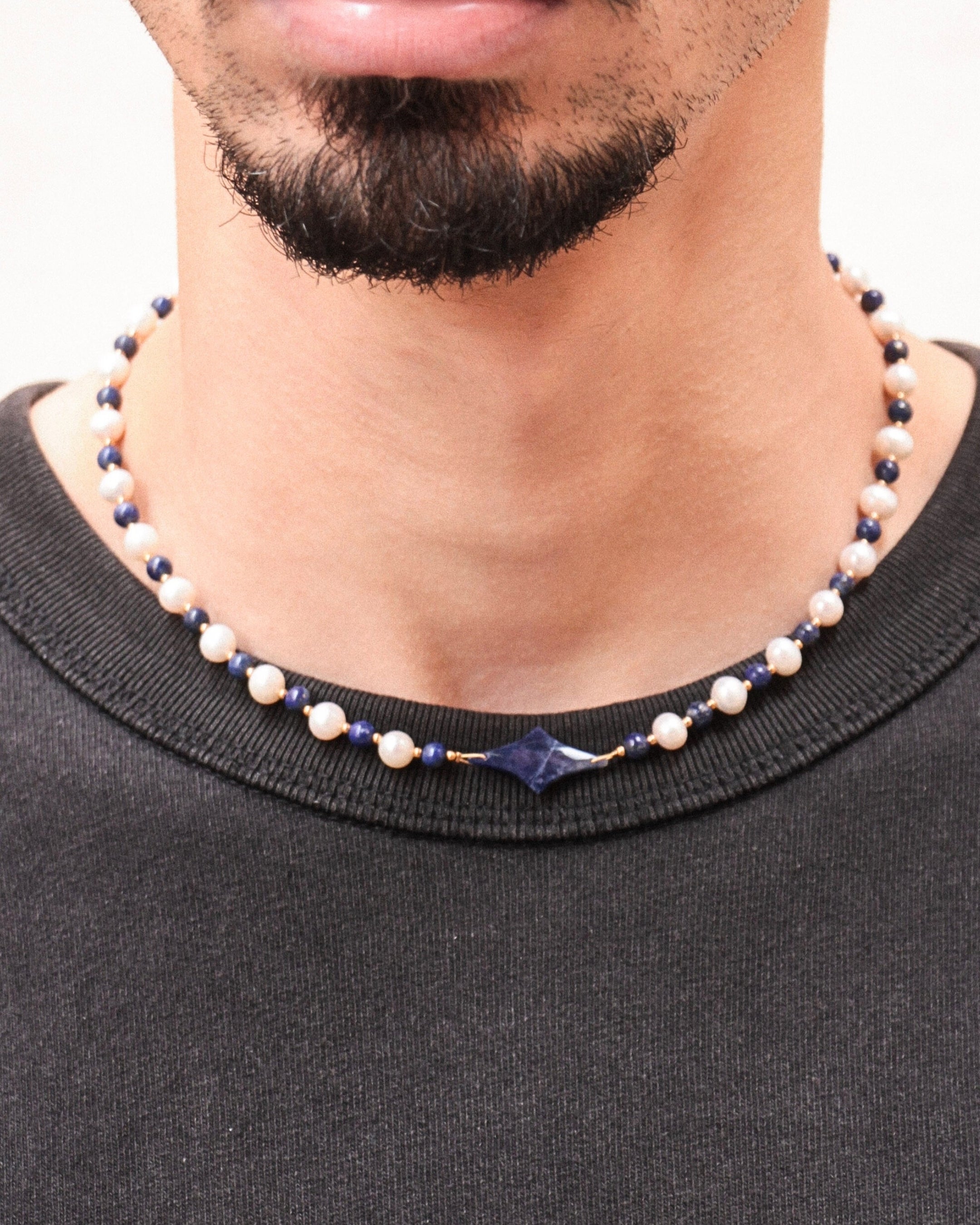 Collier Celest porté, bijou unisexe en perles d’eau douce et lapis-lazuli avec étoile centrale, finition acier inoxydable.
