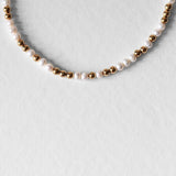 Détail du Collier Équinox en perles d’eau douce naturelles grade AAA et acier inoxydable doré à l’or 18 carats.