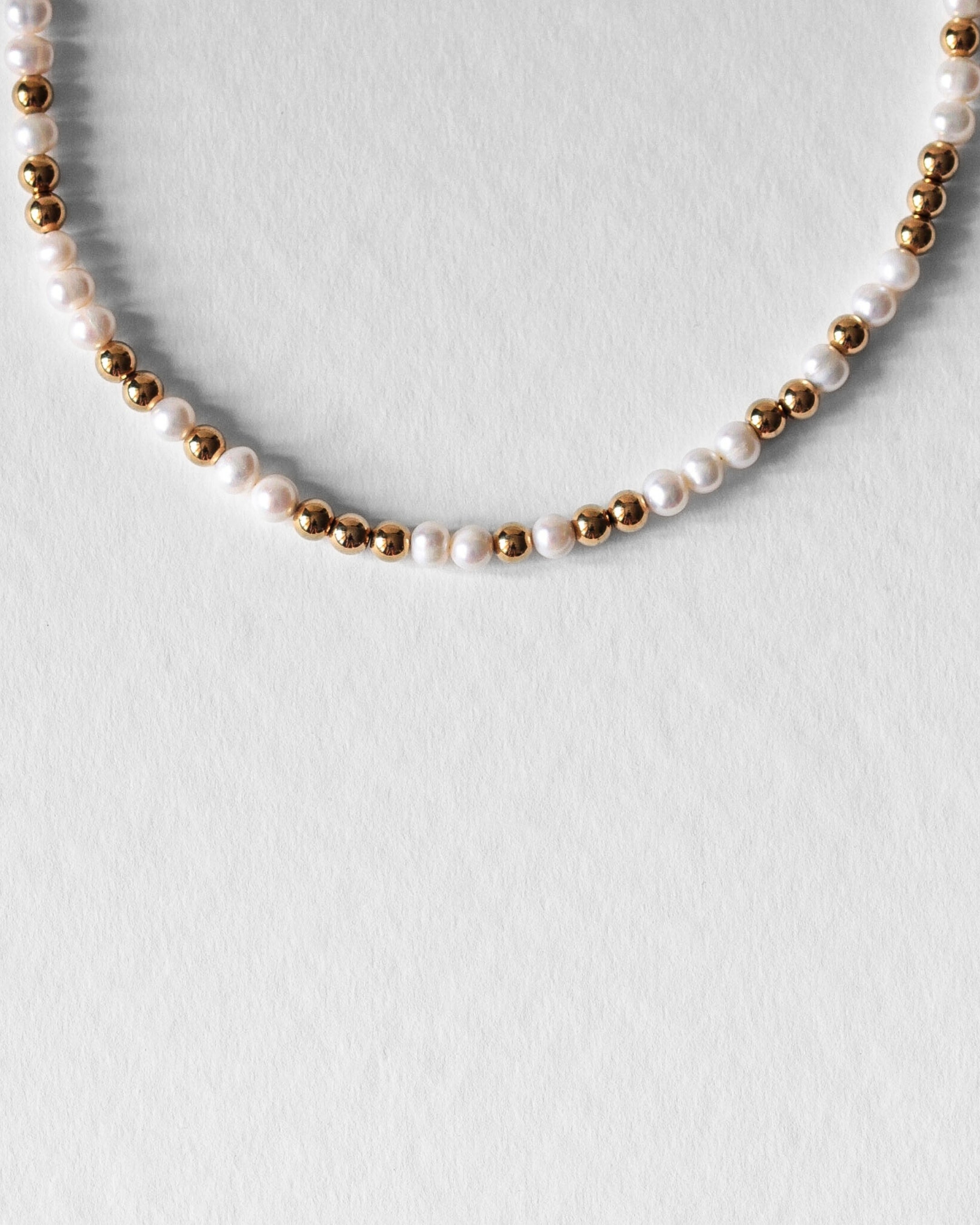 Détail du Collier Équinox en perles d’eau douce naturelles grade AAA et acier inoxydable doré à l’or 18 carats.