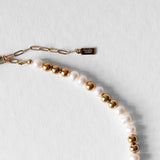Fermoir et logo signature Komète Atelier du Collier Équinox en perles d’eau douce et acier inoxydable doré.
