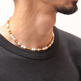 Collier Équinox en perles d’eau douce et acier inoxydable doré porté ras du cou, bijou unisexe.