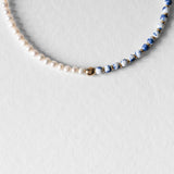 Détail du collier Kaleb en perles de céramique porcelaine bleue et perles d’eau douce, bijou artisanal Komète Atelier unisexe homme et femme.