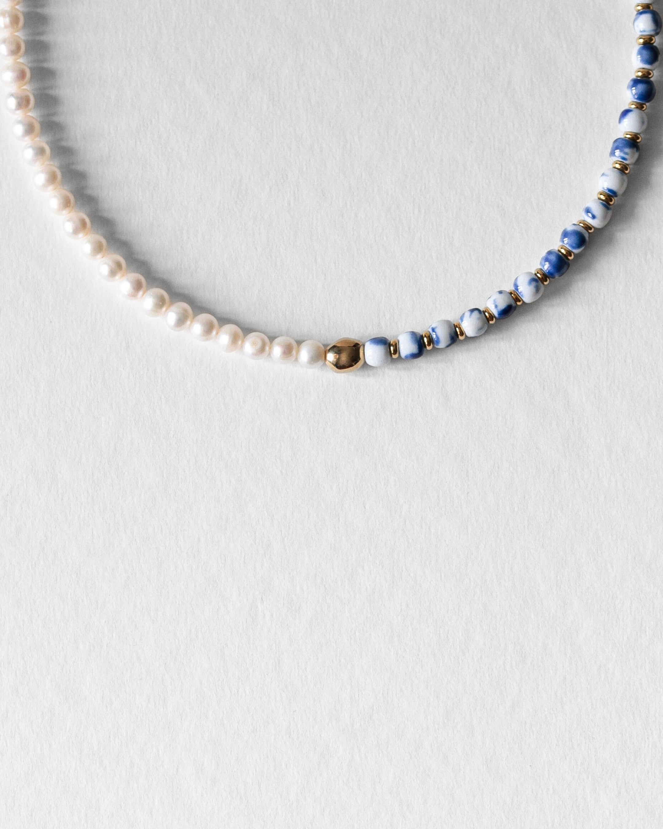Détail du collier Kaleb en perles de céramique porcelaine bleue et perles d’eau douce, bijou artisanal Komète Atelier unisexe homme et femme.