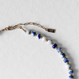 Fermoir en acier inoxydable doré du collier Kaleb, bijou artisanal Komète Atelier en perles de porcelaine bleue et perles de culture.