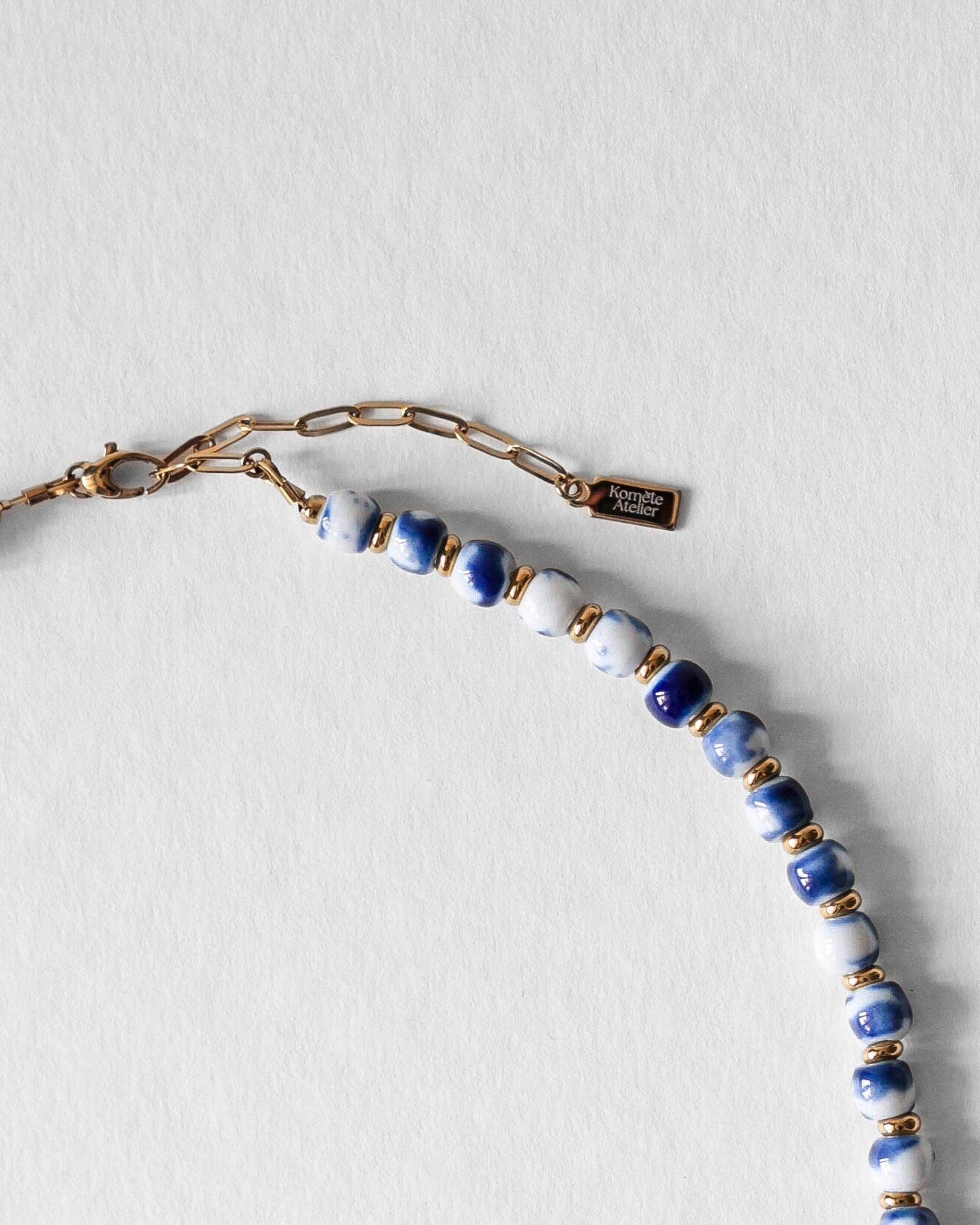 Fermoir en acier inoxydable doré du collier Kaleb, bijou artisanal Komète Atelier en perles de porcelaine bleue et perles de culture.