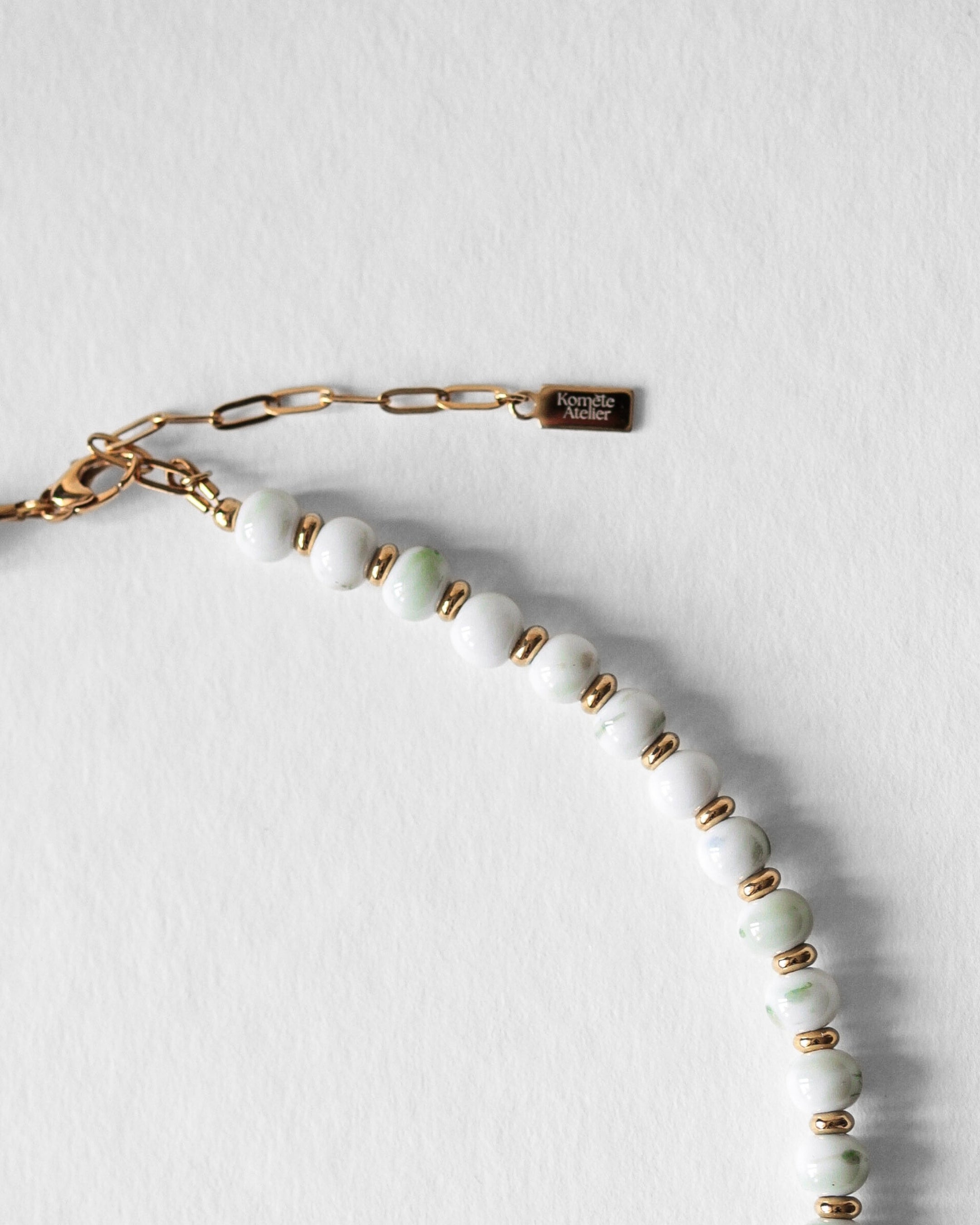 Fermoir en acier inoxydable doré du collier Kaleb, bijou artisanal Komète Atelier en perles de porcelaine verte et perles d’eau douce.