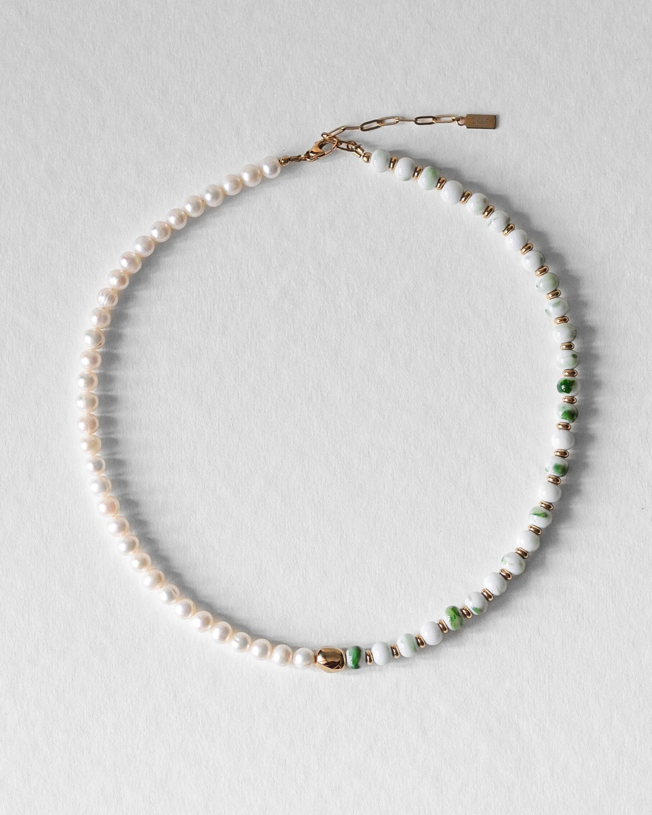 Collier Kaleb en perles de porcelaine verte et perles d’eau douce, aussi appelées perles de culture, monté sur acier inoxydable doré. Bijou artisanal fait main Komète Atelier, collier élégant unisexe pour homme et femme en céramique et perles de culture.