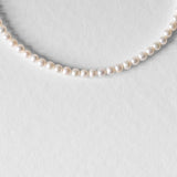 Gros plan sur le collier Harry, perles d’eau douce naturelles rondes et éclatantes, bijou artisanal unisexe.