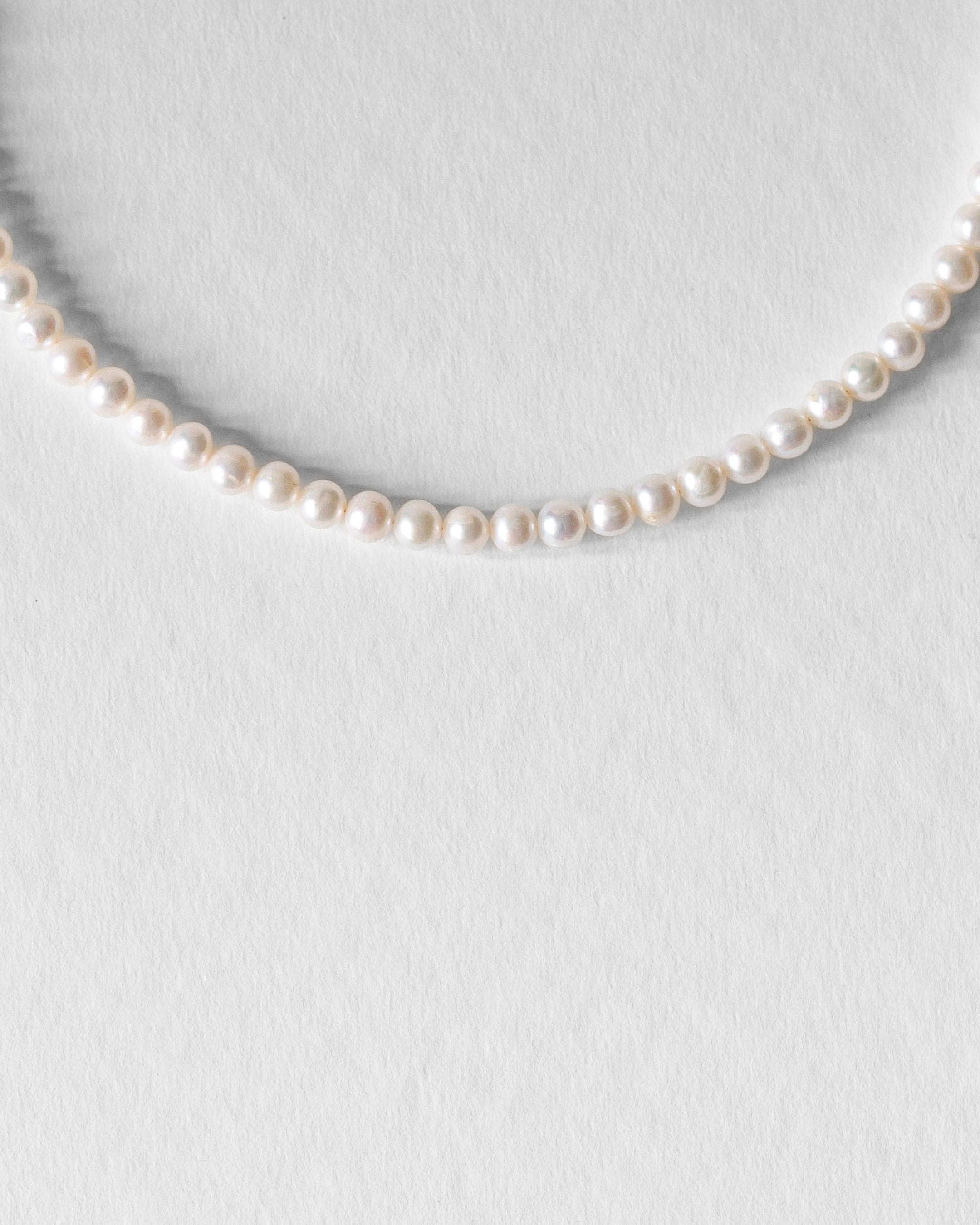 Gros plan sur le collier Harry, perles d’eau douce naturelles rondes et éclatantes, bijou artisanal unisexe.