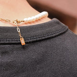 Détail du collier Harry vu de dos, fermoir en acier inoxydable doré avec logo Komète Atelier.