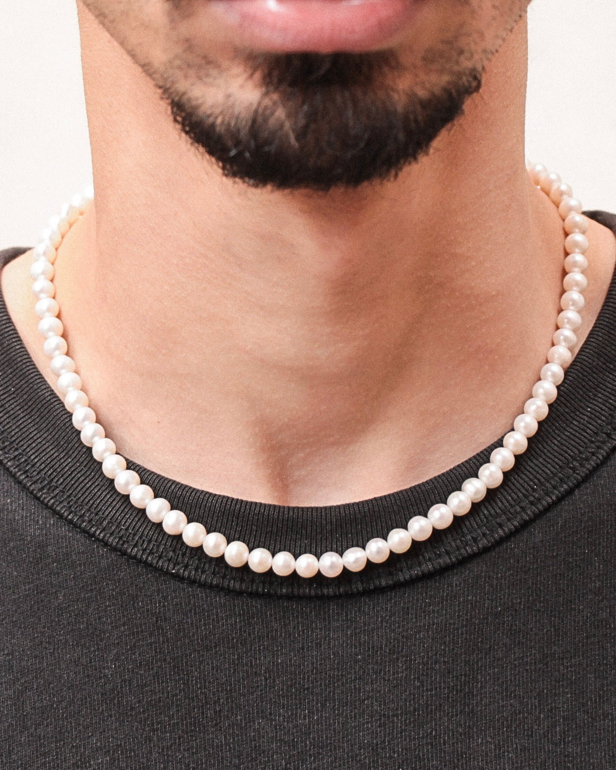 Collier Harry porté par un homme, perles d’eau douce blanches et fermoir en acier inoxydable doré, style moderne et raffiné.